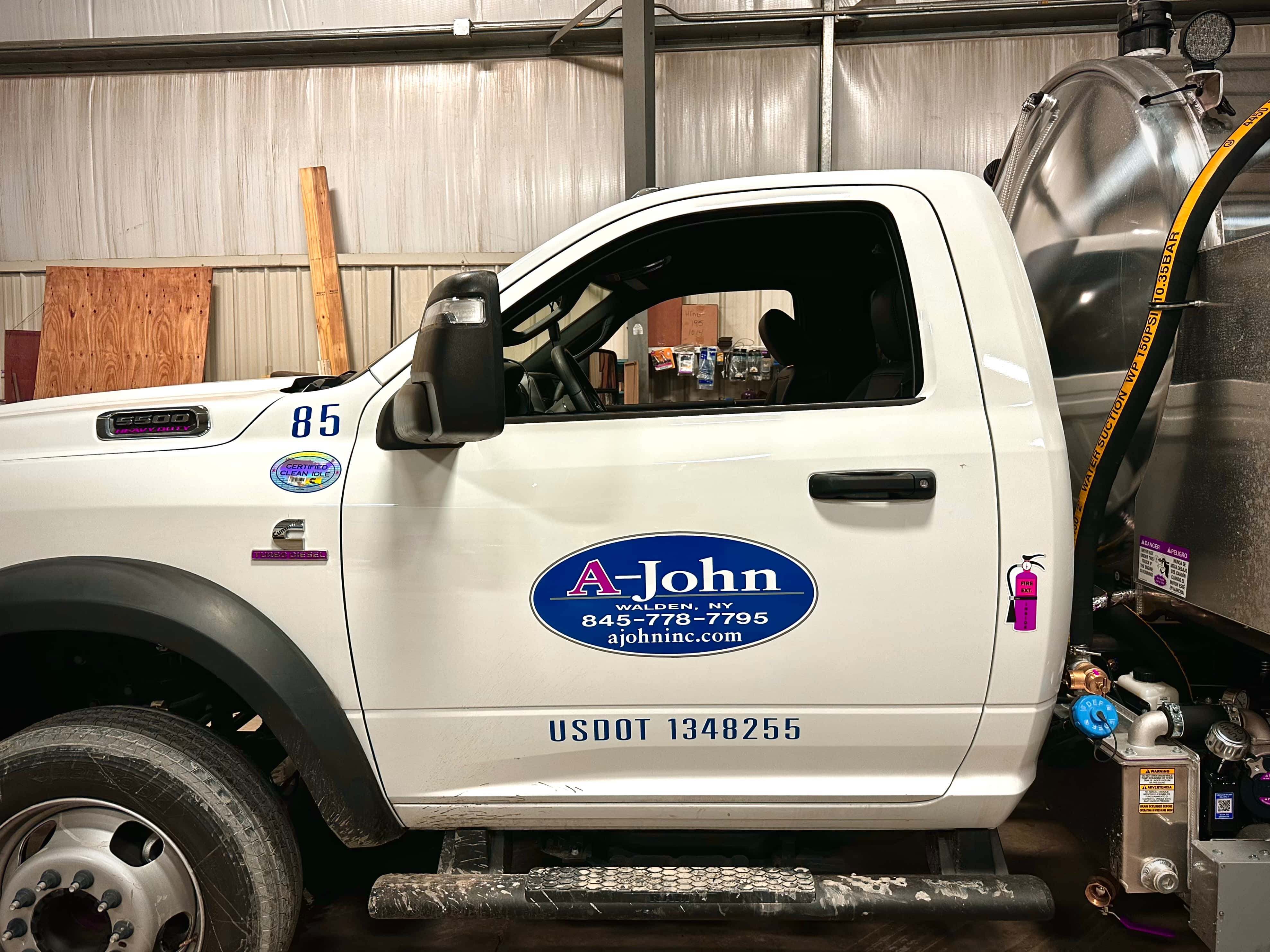 A-John Inc. team member standing beside portable sanitation units